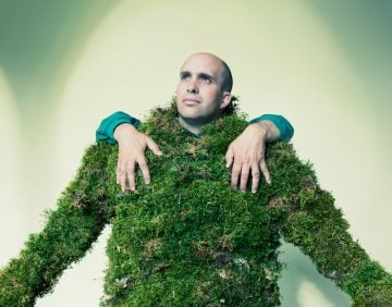 Man dressed in moss with hands on his shoulders.  The Moss Men of Bejar.