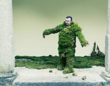 Man trying to walk in a suit of moss.  The Moss Men of Bejar.