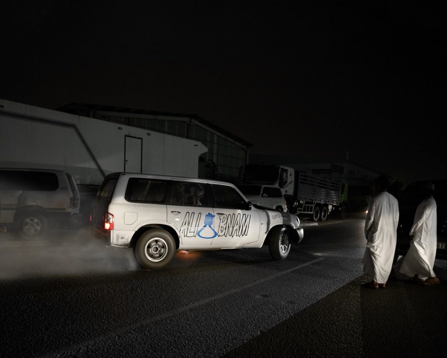 Onlookers watch a drifter cornering on a public street in Dubai.