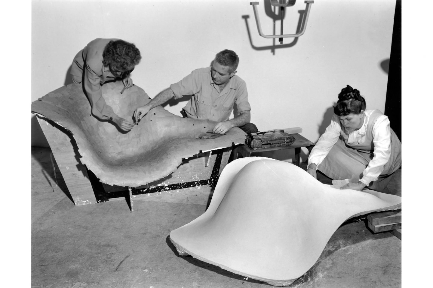 Frances Bishop, Robert Jacobsen and Ray Eames working on the mould for La Chaise, 1948. ∏ Eames Office LLC