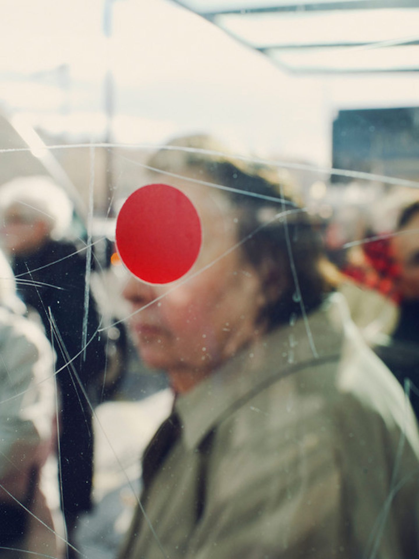 FRANCE. Sete. 2012. A red dot on the glass of a bus stop.